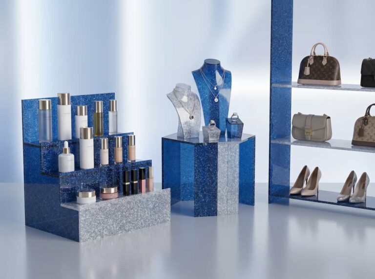High-end luxury retail display stands made of blue and silver glitter acrylic sheets showcasing premium cosmetics and fashion accessories.