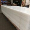 large-white-acrylic-sheets-warehouse Large white acrylic sheets stacked in a factory warehouse